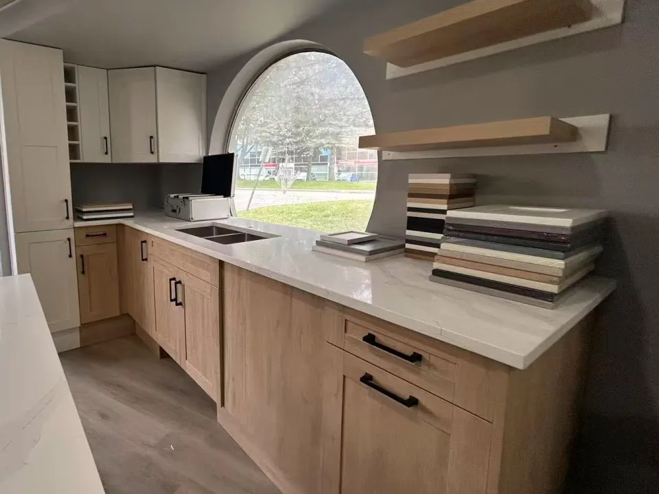 The display kitchen in the T&F showroom, with natural oak cabinets, white uppers and the round window.